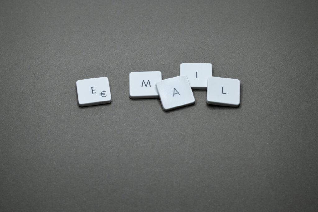 Close-up of the word 'email' formed with letter tiles on a gray surface.